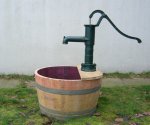 Holzfass als Mini-Teich mit Schwengelpumpe / Handpumpe im schlichten Design.